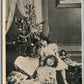 LITTLE SISTERS w/ DOLLS UNDER CHRISTMAS TREE ANTIQUE POSTCARD