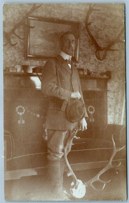 HUNTER w/ TOBACCO PIPE in HUNTING TROPHY ROOM ANTIQUE REAL PHOTO POSTCARD RPPC