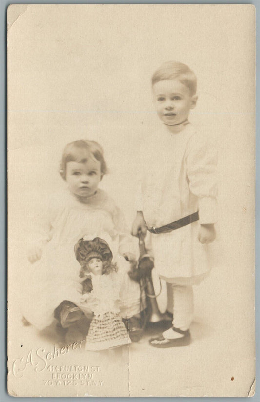 LITTLE GIRL & BOY w/ LARGE DOLL 1912 ANTIQUE REAL PHOTO POSTCARD RPPC